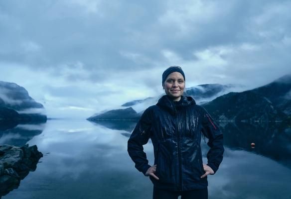 Kvinne foran fjord med lavt skydekke